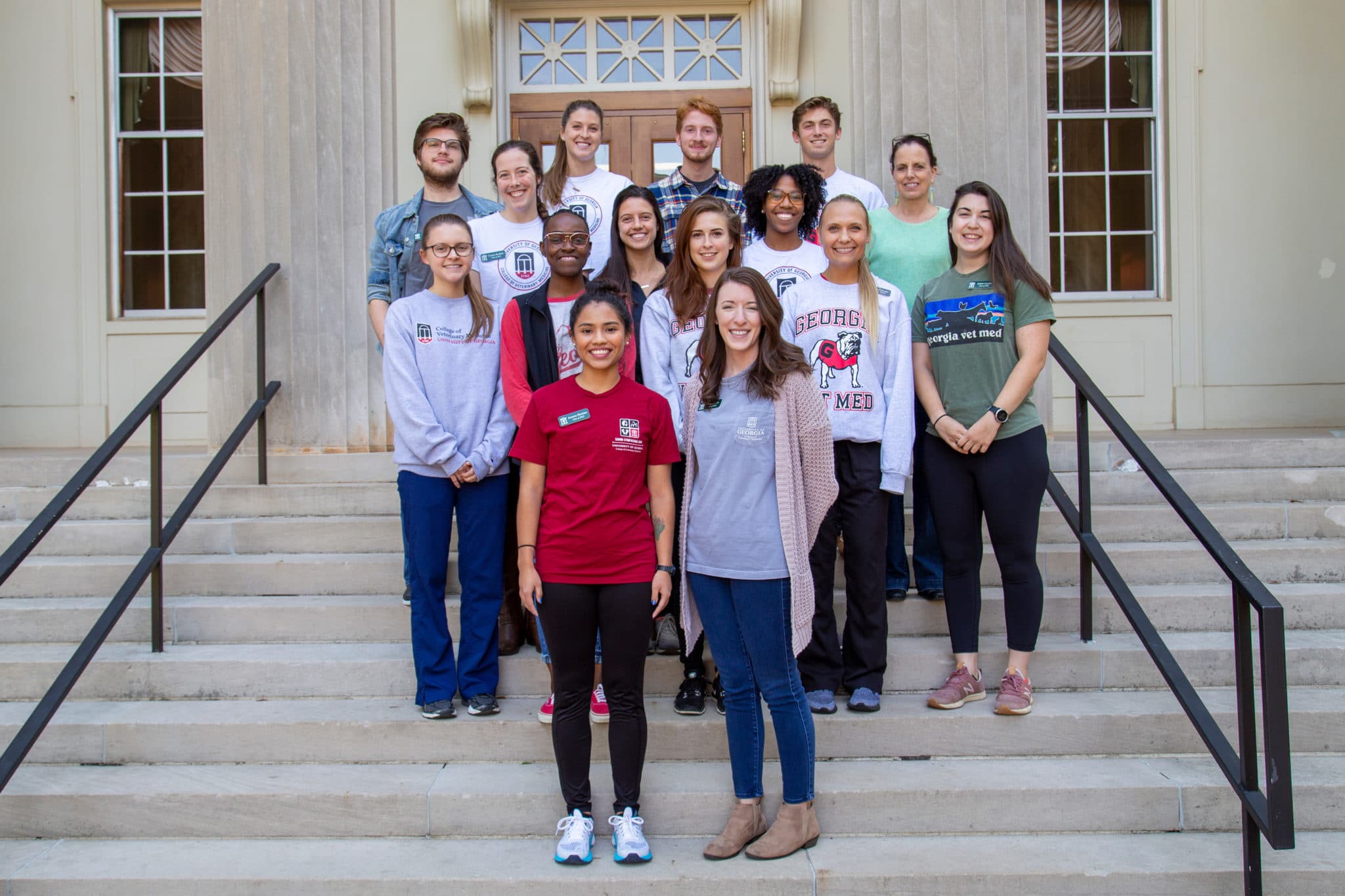 The 14 participating students stand with Dr. Hondalus on the steps in front of the CVM.