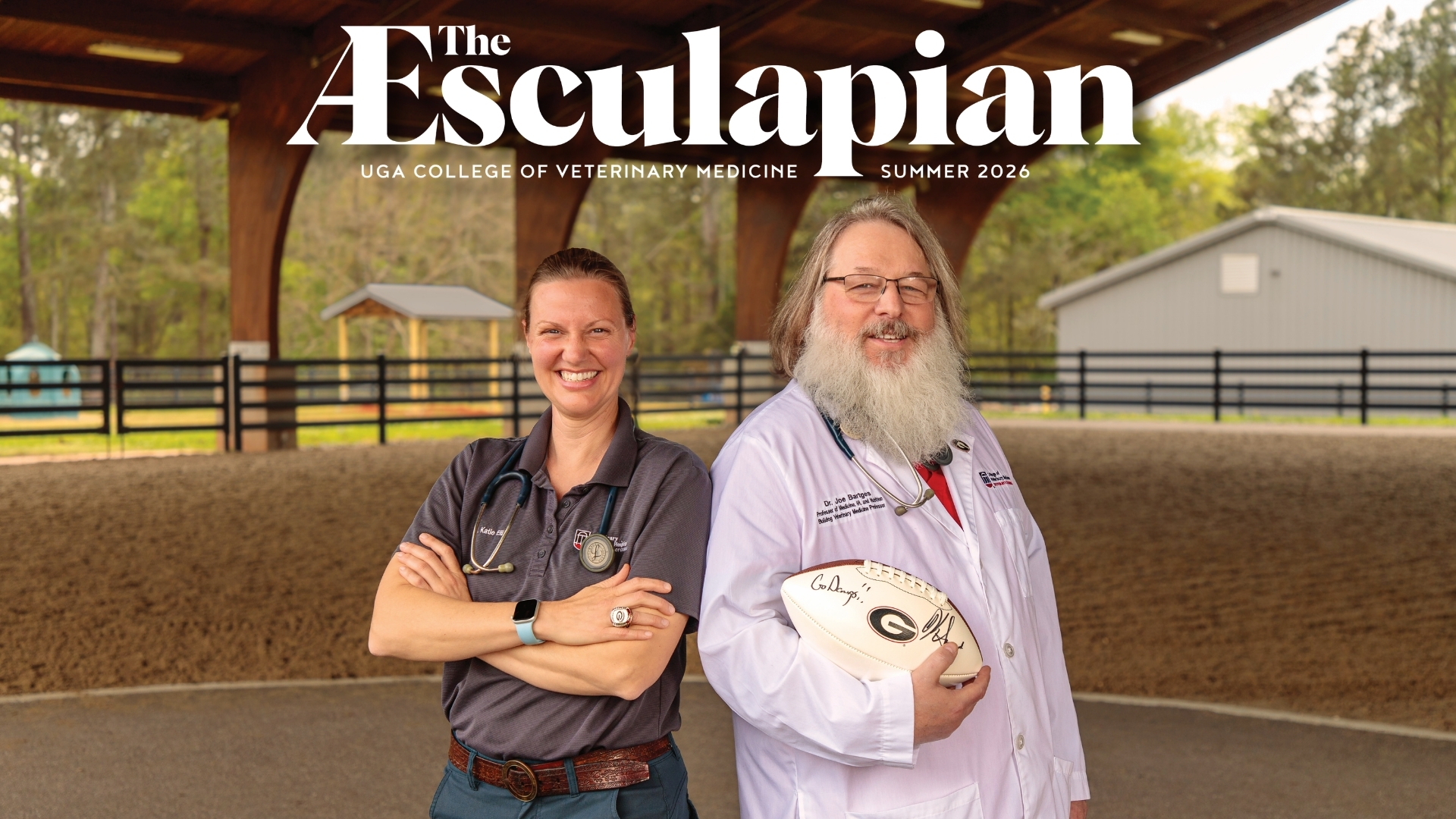 Cover of the æsculapian, uga college of veterinary medicine, summer 2026. Dr. Katie ellis, in a gray polo with a stethoscope and equestrian championship ring, stands next to dr. Joe bartges, in a white lab coat, holding a football signed "go dawgs. " they're smiling under a wooden riding arena pavilion, with a horse fence and barn in the background.